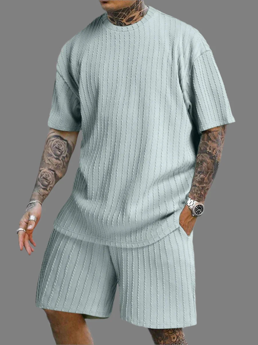 Person wearing a light green ribbed outfit with matching shorts on a gray background