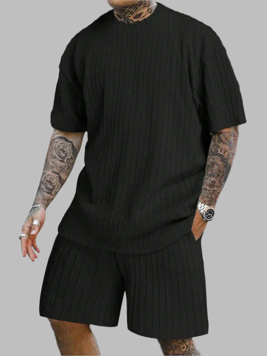 Person wearing a black ribbed knit outfit on a gray background