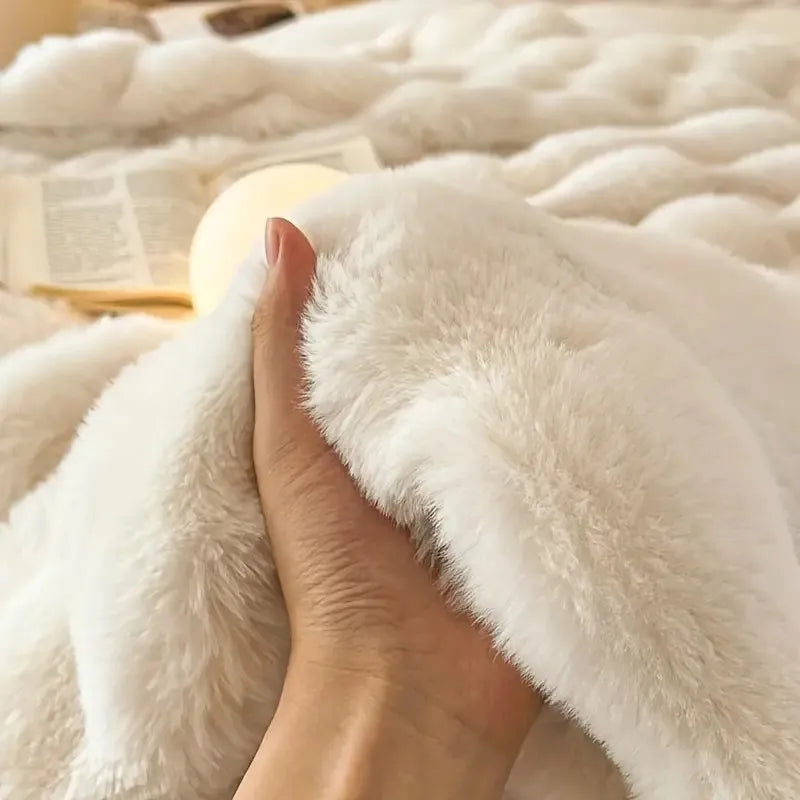 Close-up of a hand holding a fluffy white blanket
