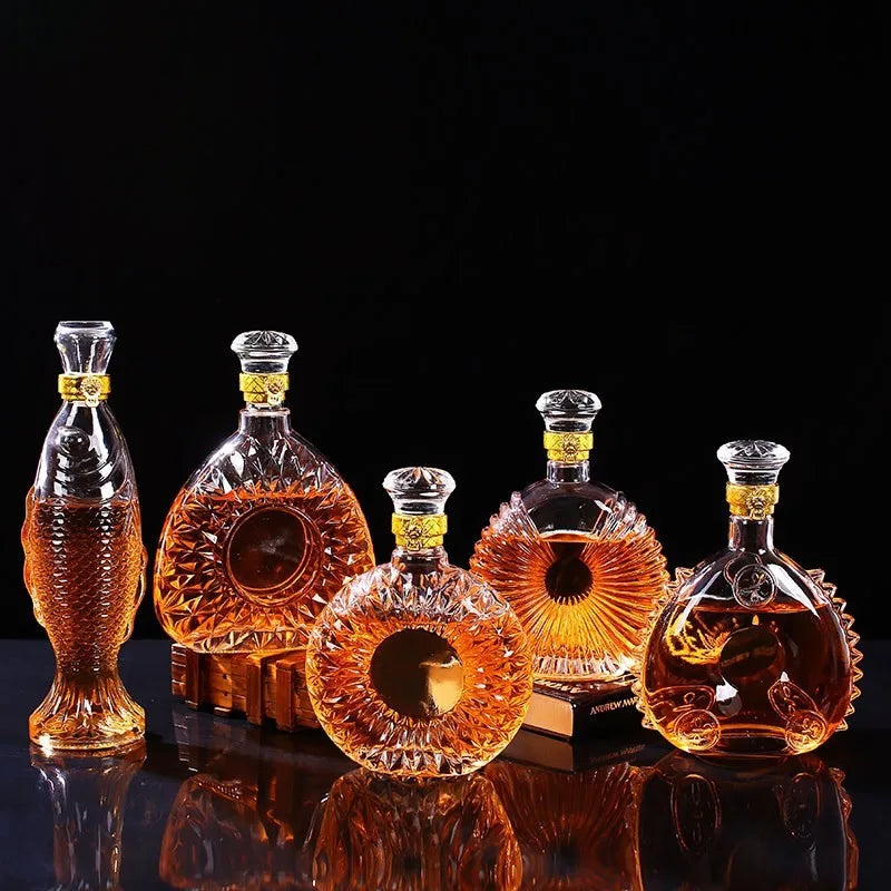 Set of glass decanters with amber liquid on a reflective surface with a black background