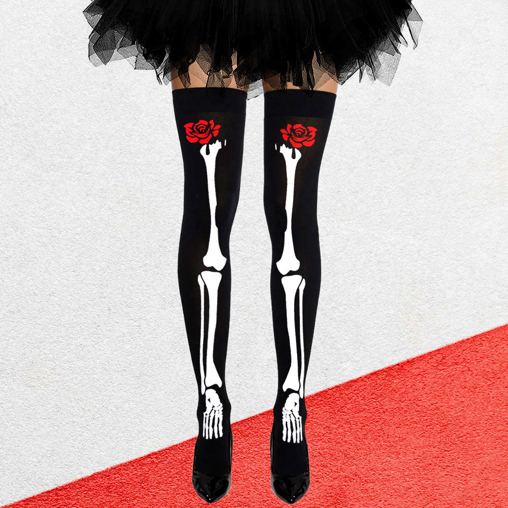 Black skeleton tights with red roses worn by a person on a red carpet.