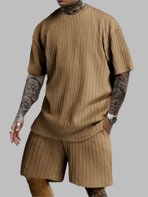 Person wearing a brown ribbed knit outfit on a gray background