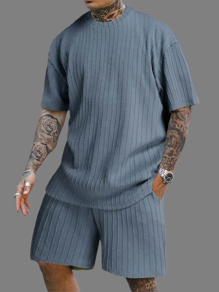 Person wearing a ribbed blue sweater and shorts set on a gray background