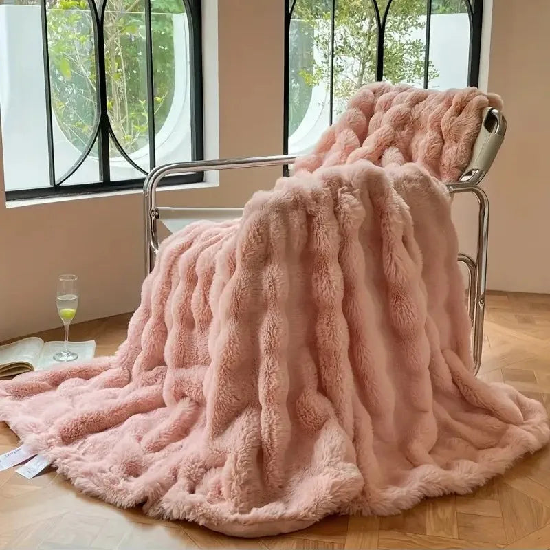 Pink fluffy blanket draped over a chair in a room with large windows.