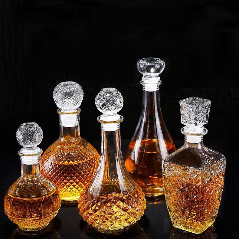 Set of glass decanters with intricate designs on a black background