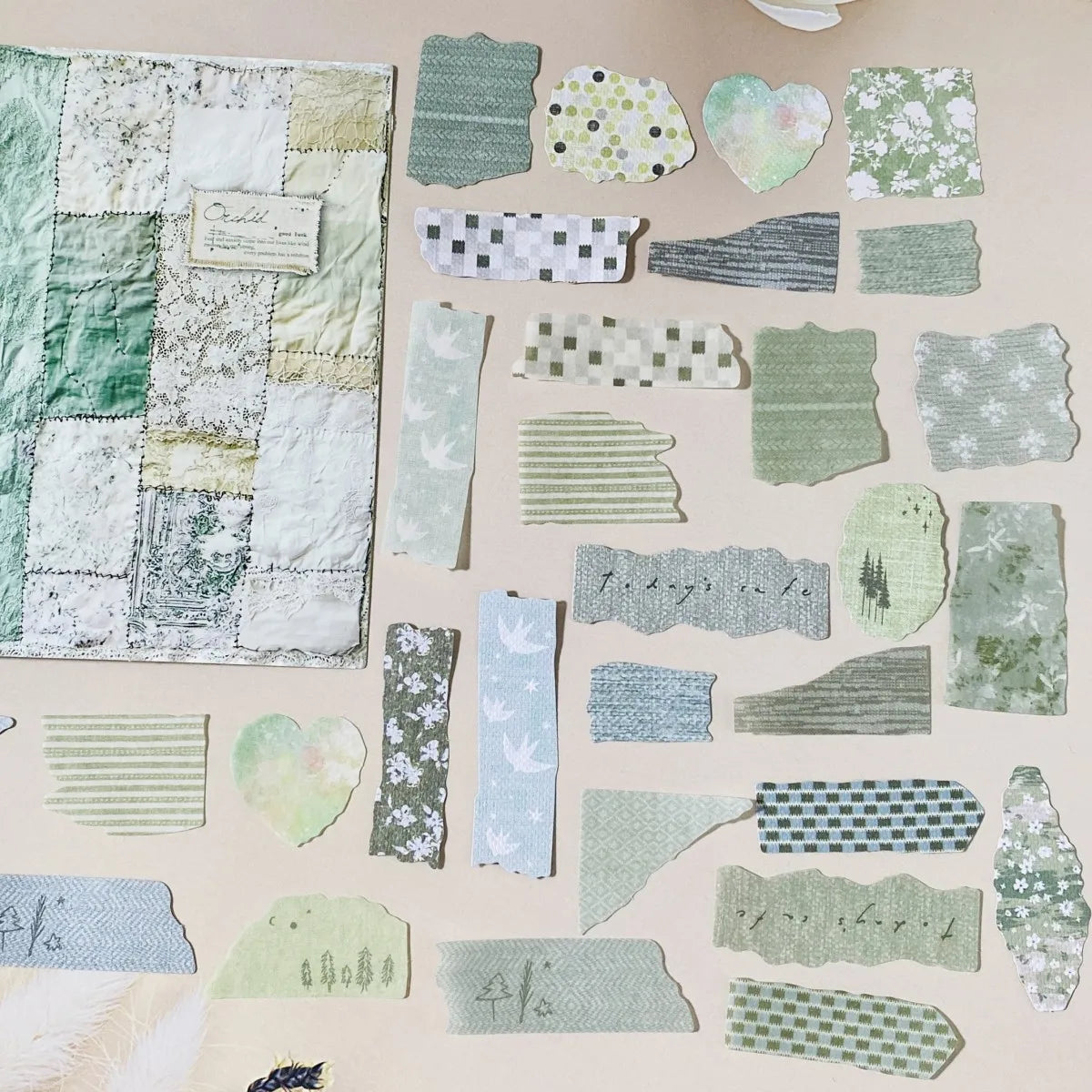Collection of green textured paper pieces on a beige background