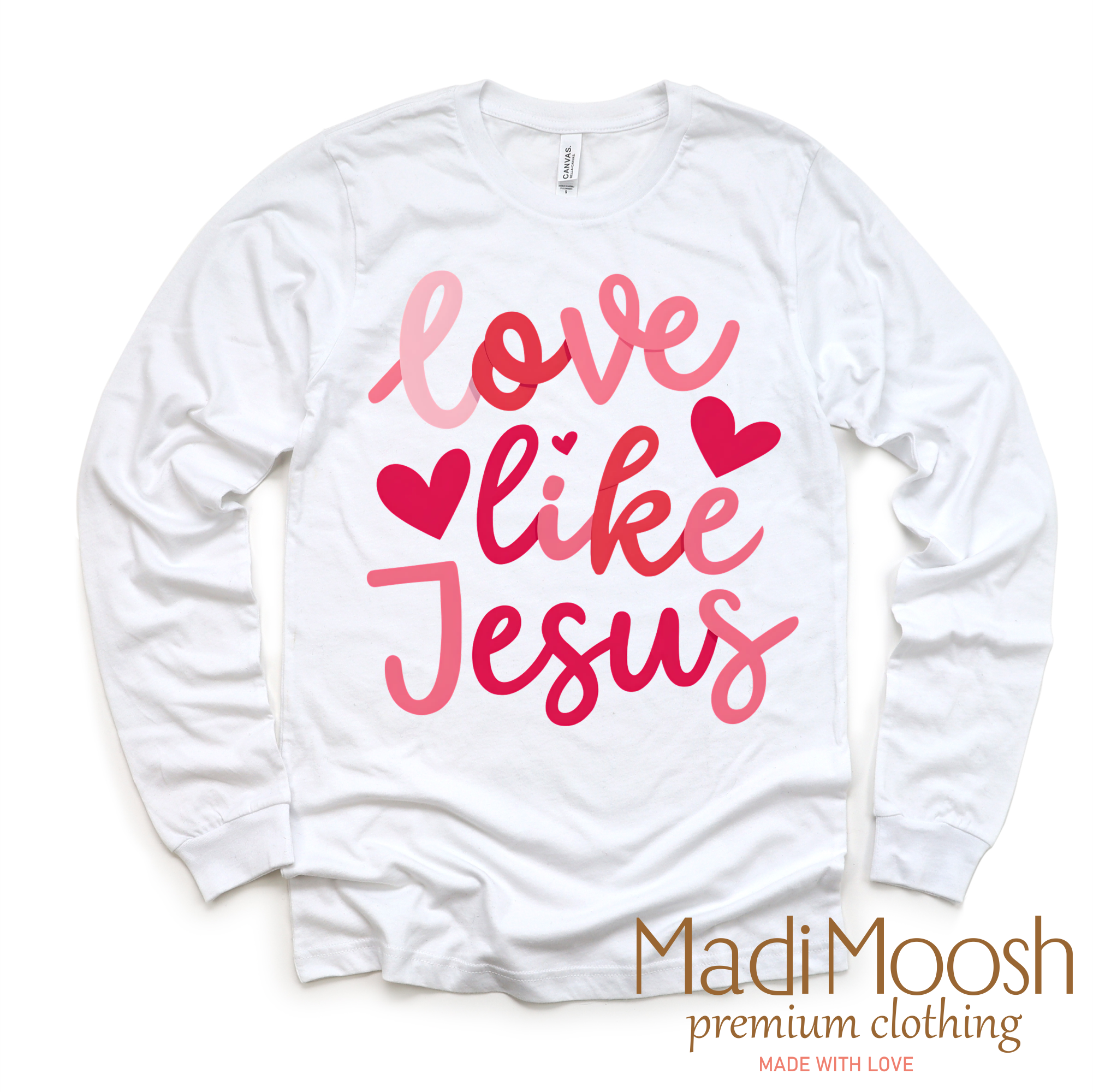 White long sleeve shirt with pink text 'Love like Jesus' and Madi Moosh branding on a white background