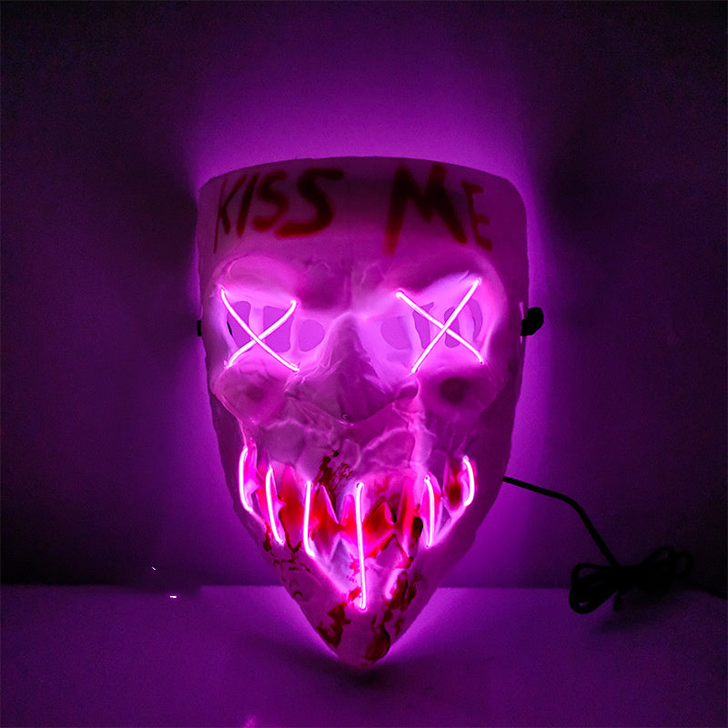 Glowing skull mask with 'Kiss Me' text on a purple background