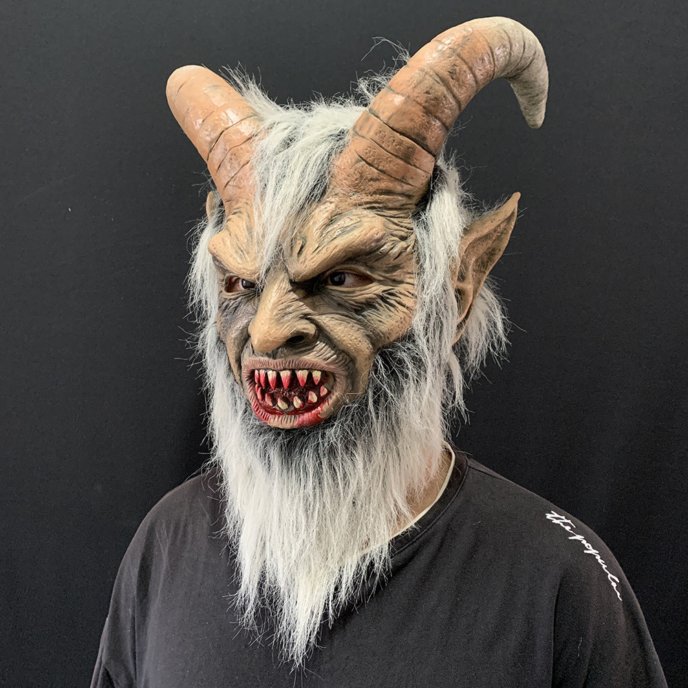 Person wearing a detailed mask with horns and beard against a black background