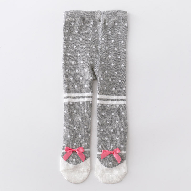 A pair of gray knit tights with white polka dots, white toe caps, white horizontal stripes, and pink ribbon bows at the heels, shown flat on a light gray background.