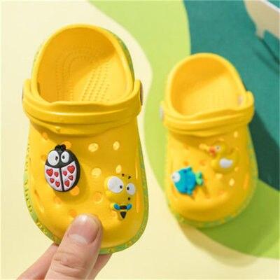 Yellow children's clogs with decorative elements on a colorful background