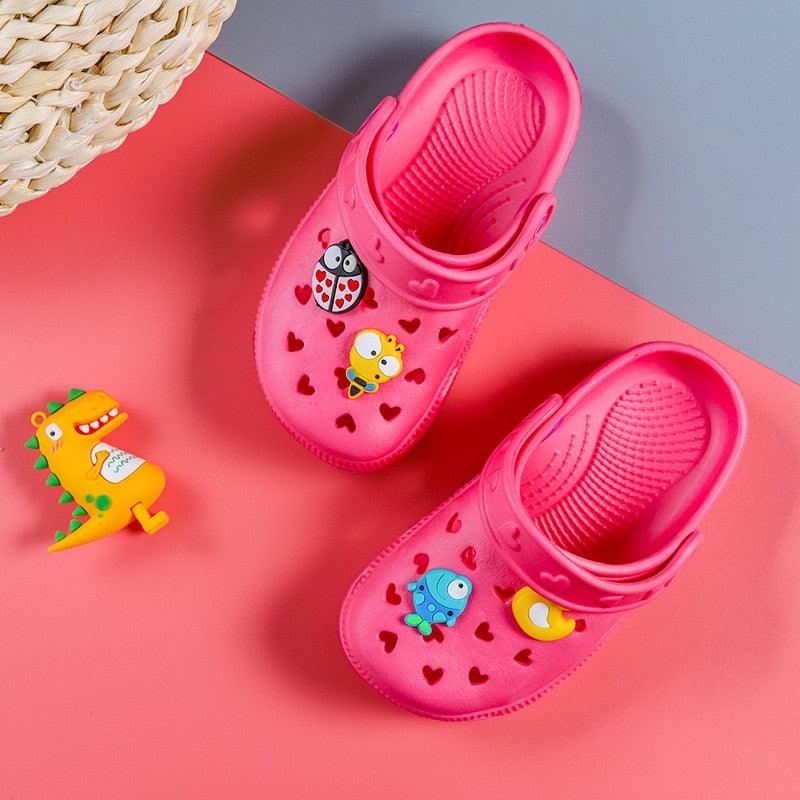 Pink children's sandals with cartoon characters on a pink and gray background