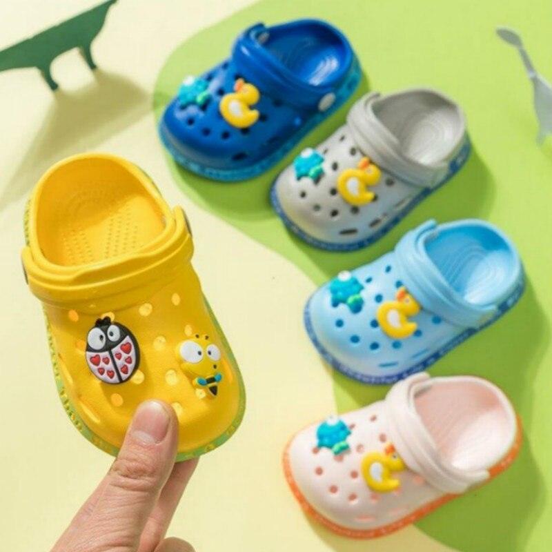 Colorful children's clogs with cartoon designs on a green background