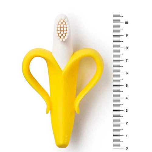 Yellow banana-shaped toothbrush holder with a white toothbrush on a white background with a ruler for scale.