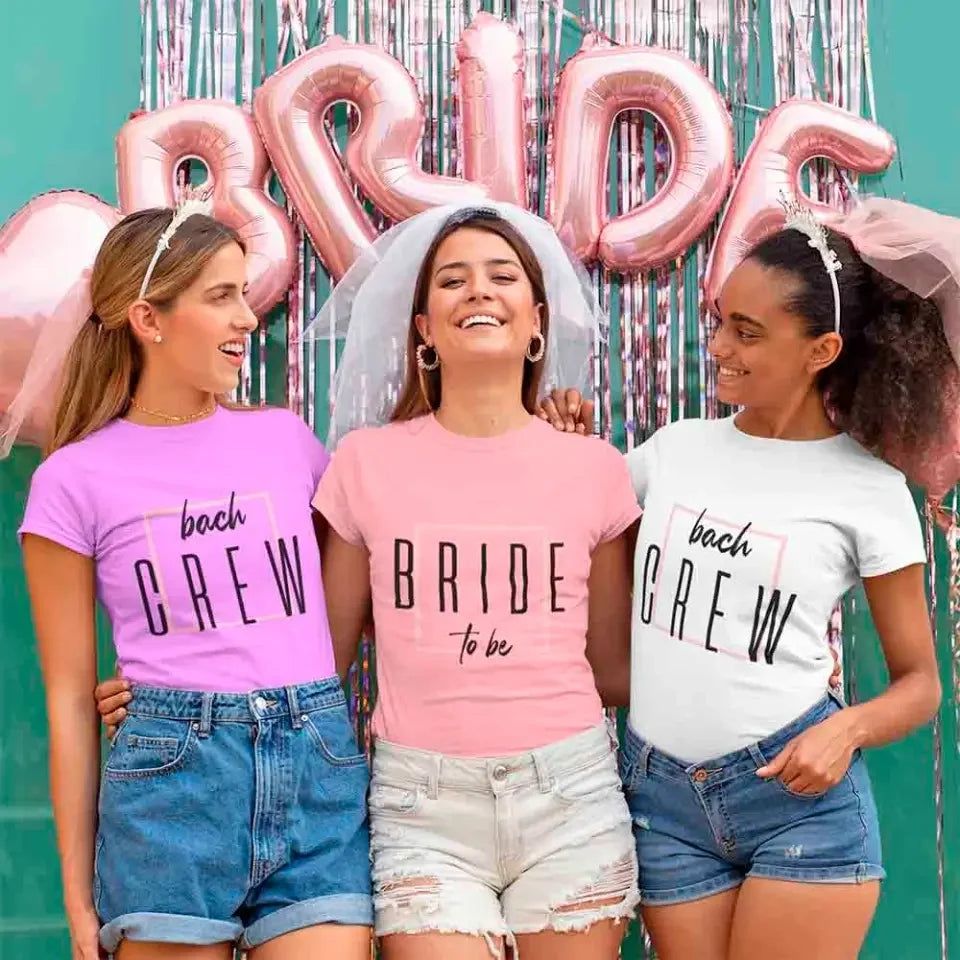 Three women wearing 'Bride to be' and 'Bachelorette Crew' shirts with pink and silver balloons in the background.