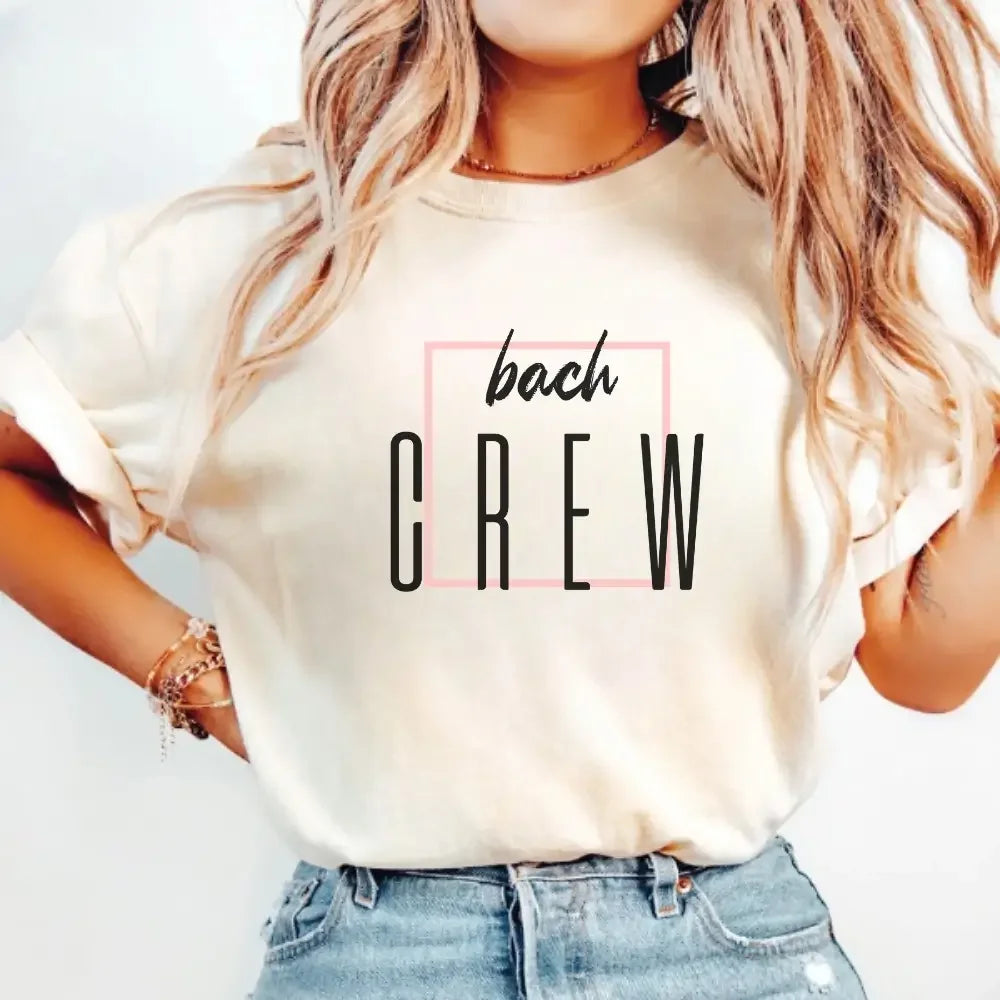 Person wearing a white t-shirt with 'bach CREW' text design.