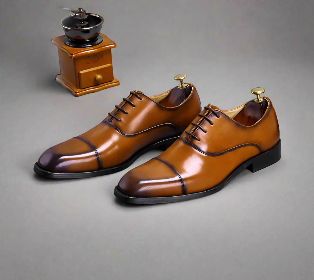 Pair of brown leather shoes with striped design on a gray background