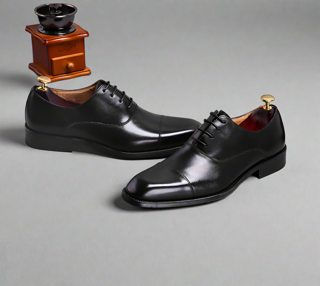 Pair of black dress shoes on a gray background