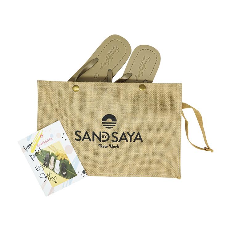 Pair of sandals in a jute bag with 'SAND SAYA' branding on a white background