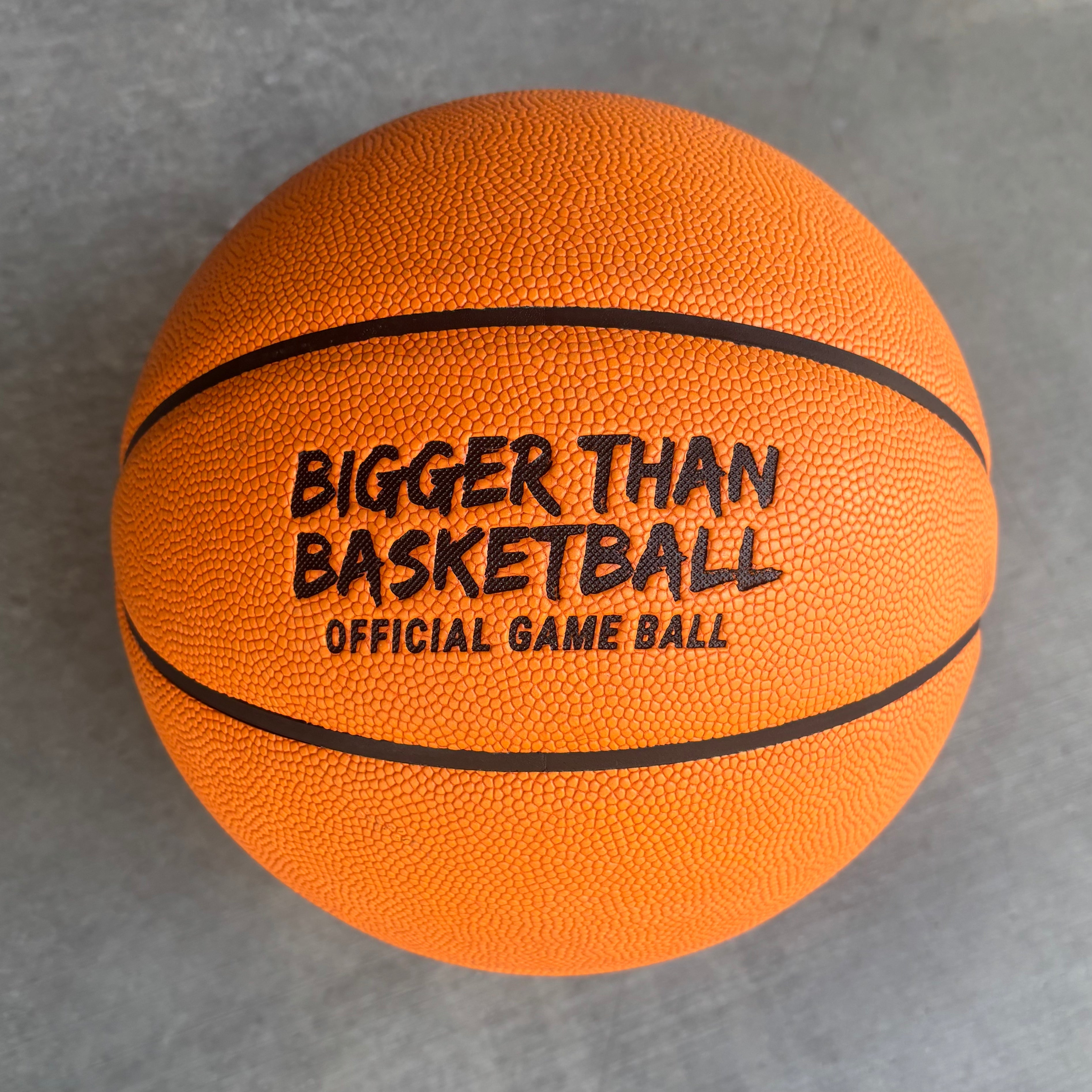 Orange basketball with 'Bigger Than Basketball' text on a gray background