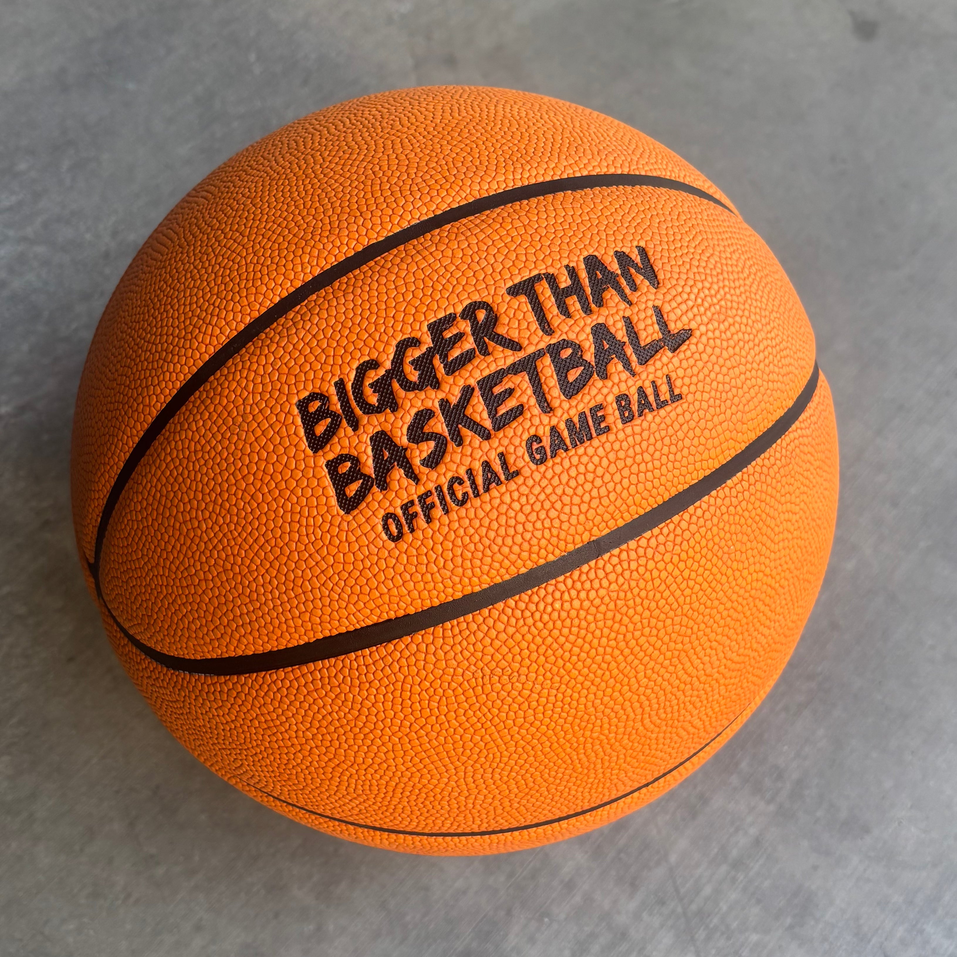 Orange basketball with 'Bigger Than Basketball' text on a gray background