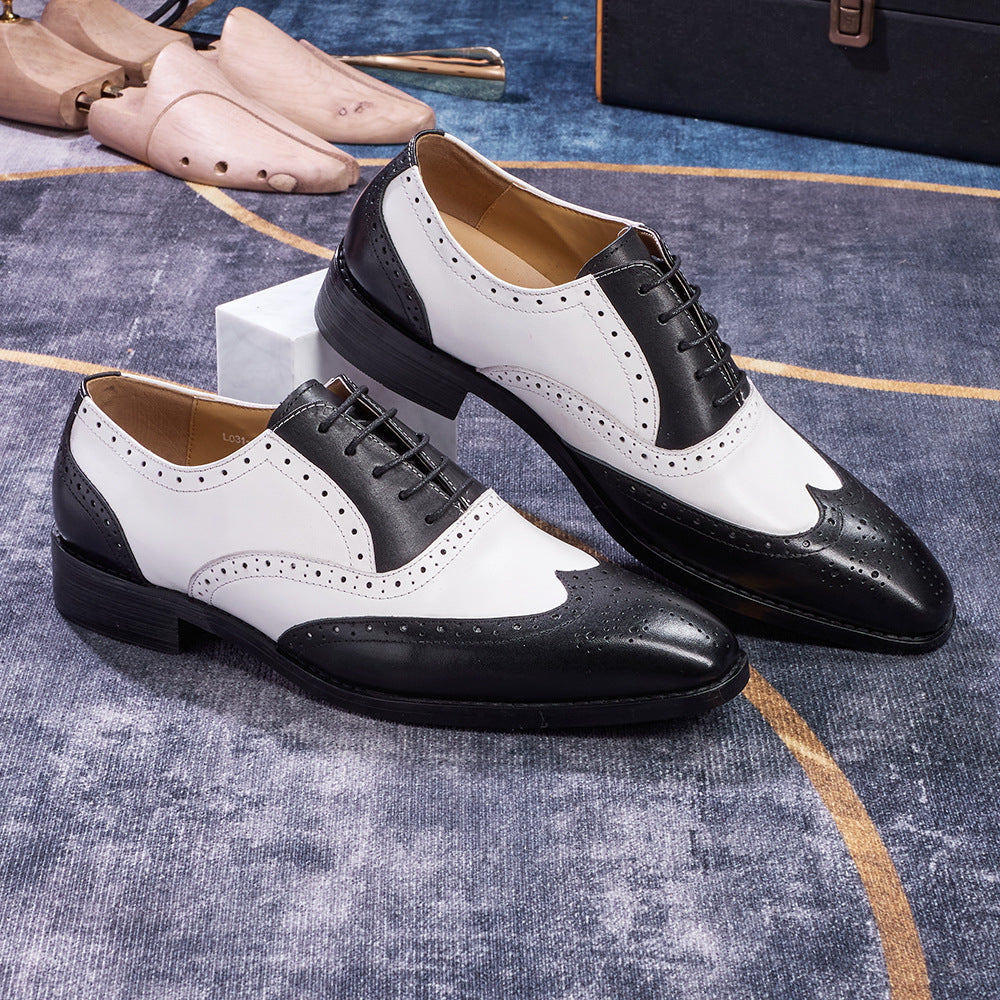 Black and white dress shoes on a textured surface with other shoes in the background.