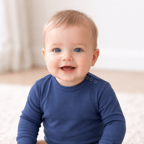 Baby wearing a blue long-sleeve shirt with a plain background