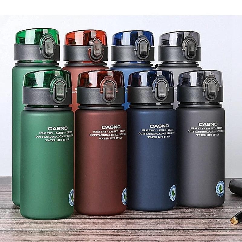 Set of Casno water bottles in various colors on a wooden surface.