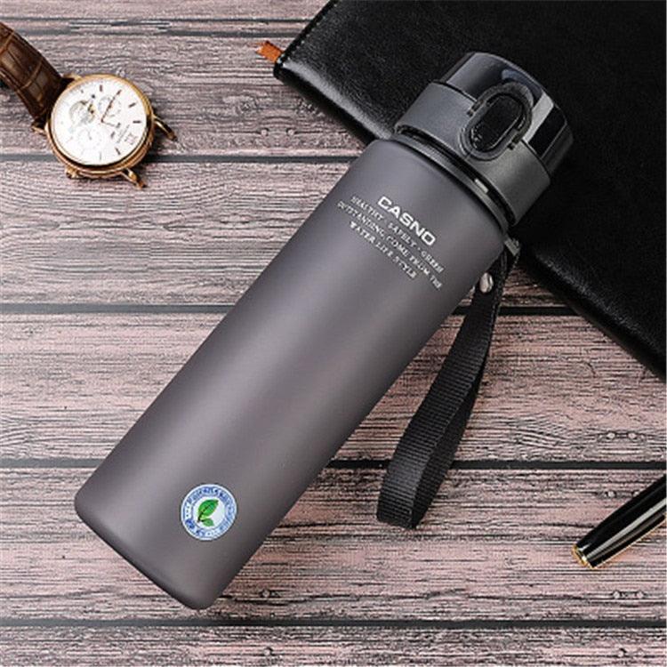 Gray water bottle with a strap on a wooden surface, featuring the Casno brand.