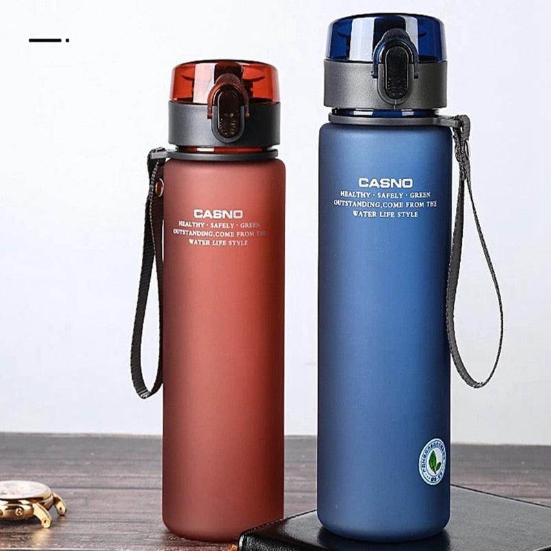 Two Casno water bottles, one red and one blue, on a wooden surface with a white background.