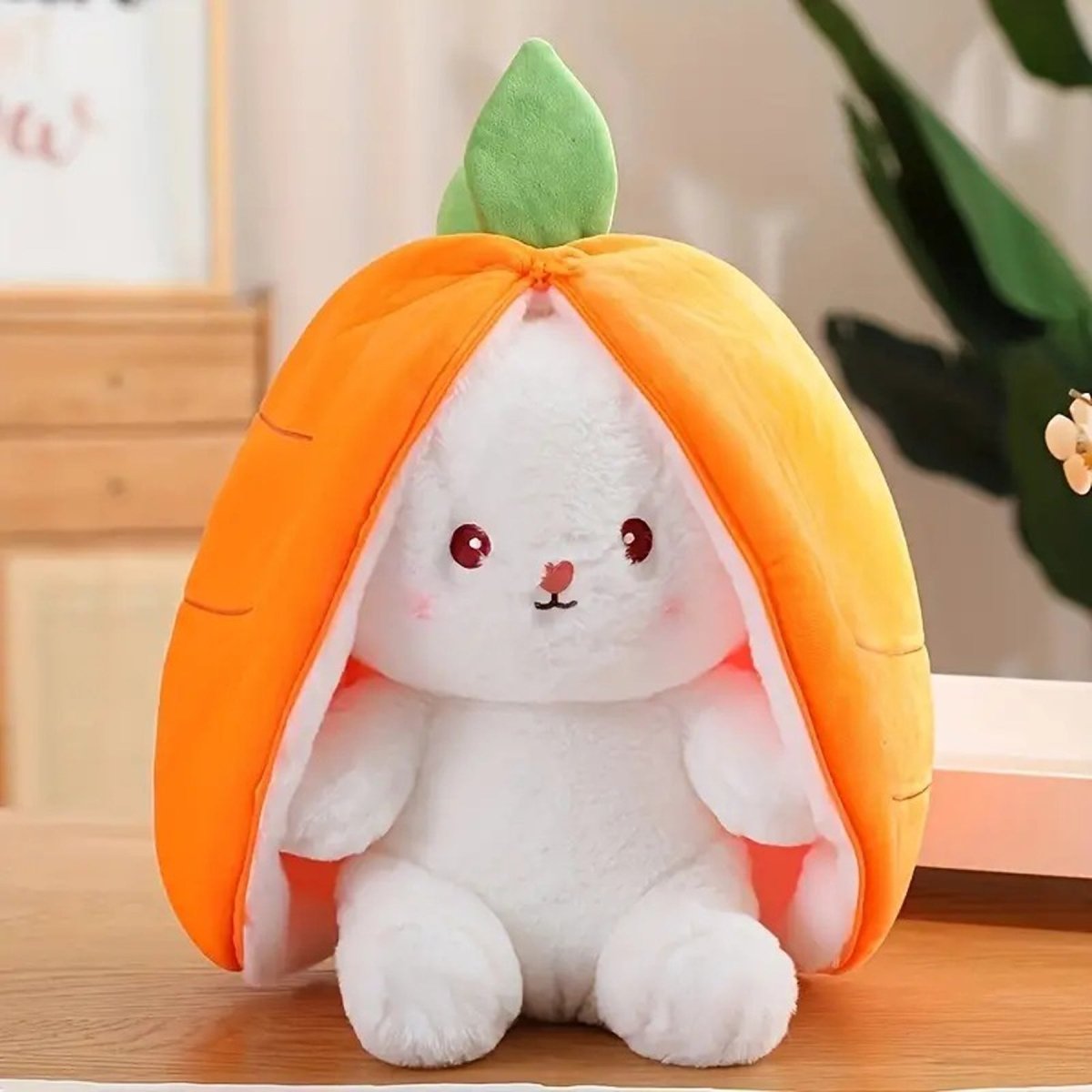 Plush toy with a white rabbit face inside an orange shell on a wooden surface.