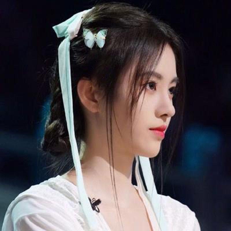 Woman with traditional hairstyle and attire against a dark background