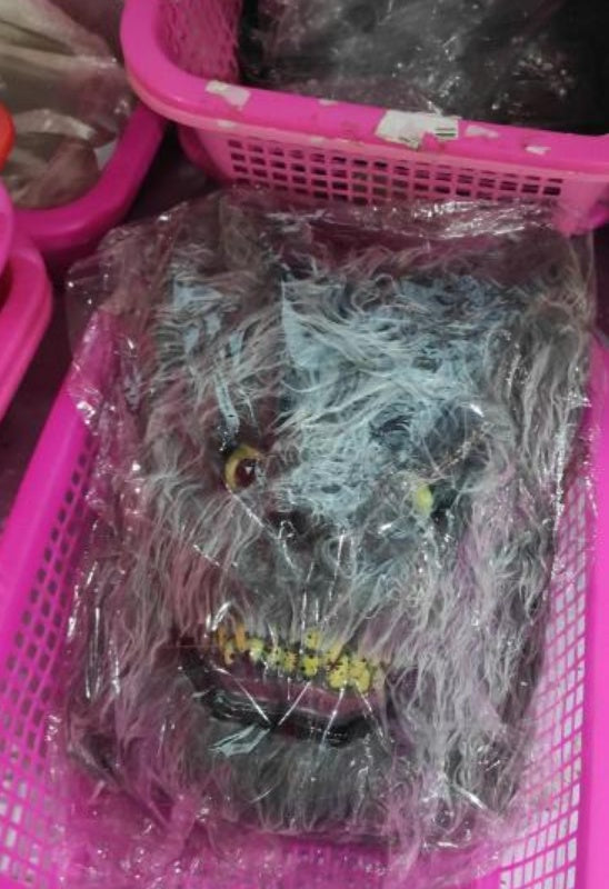 Toy figure wrapped in plastic inside a pink basket