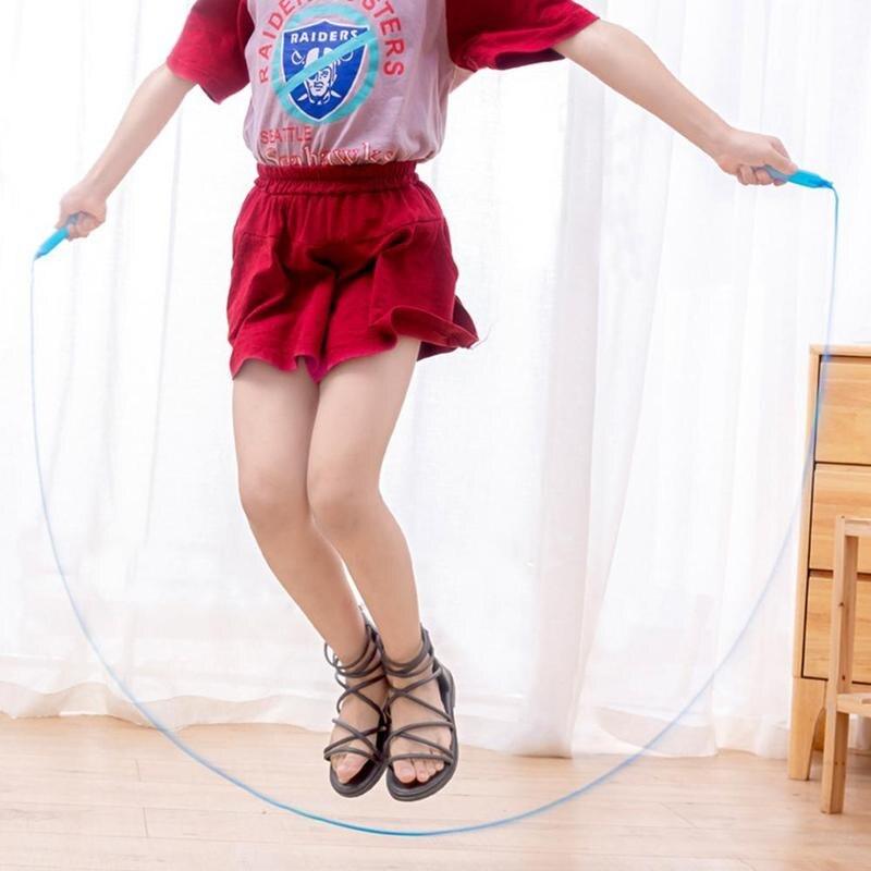 Person in red outfit with 'Raiders' logo skipping rope indoors.