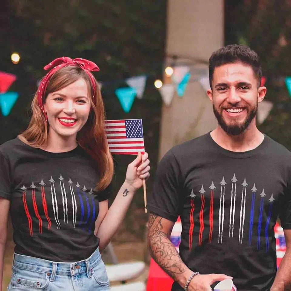 Two people wearing matching black t-shirts with a design, holding an American flag.
