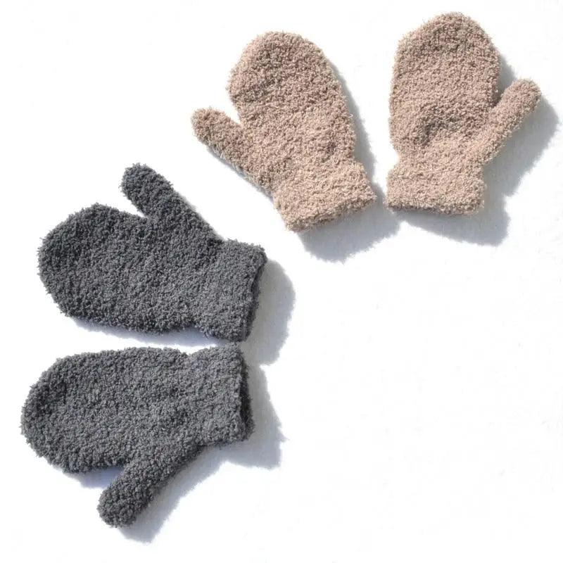 Pair of gray fuzzy gloves and a pair of beige fuzzy mittens on a white background