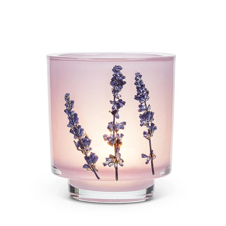 Glass candle holder with lavender flowers on a white background
