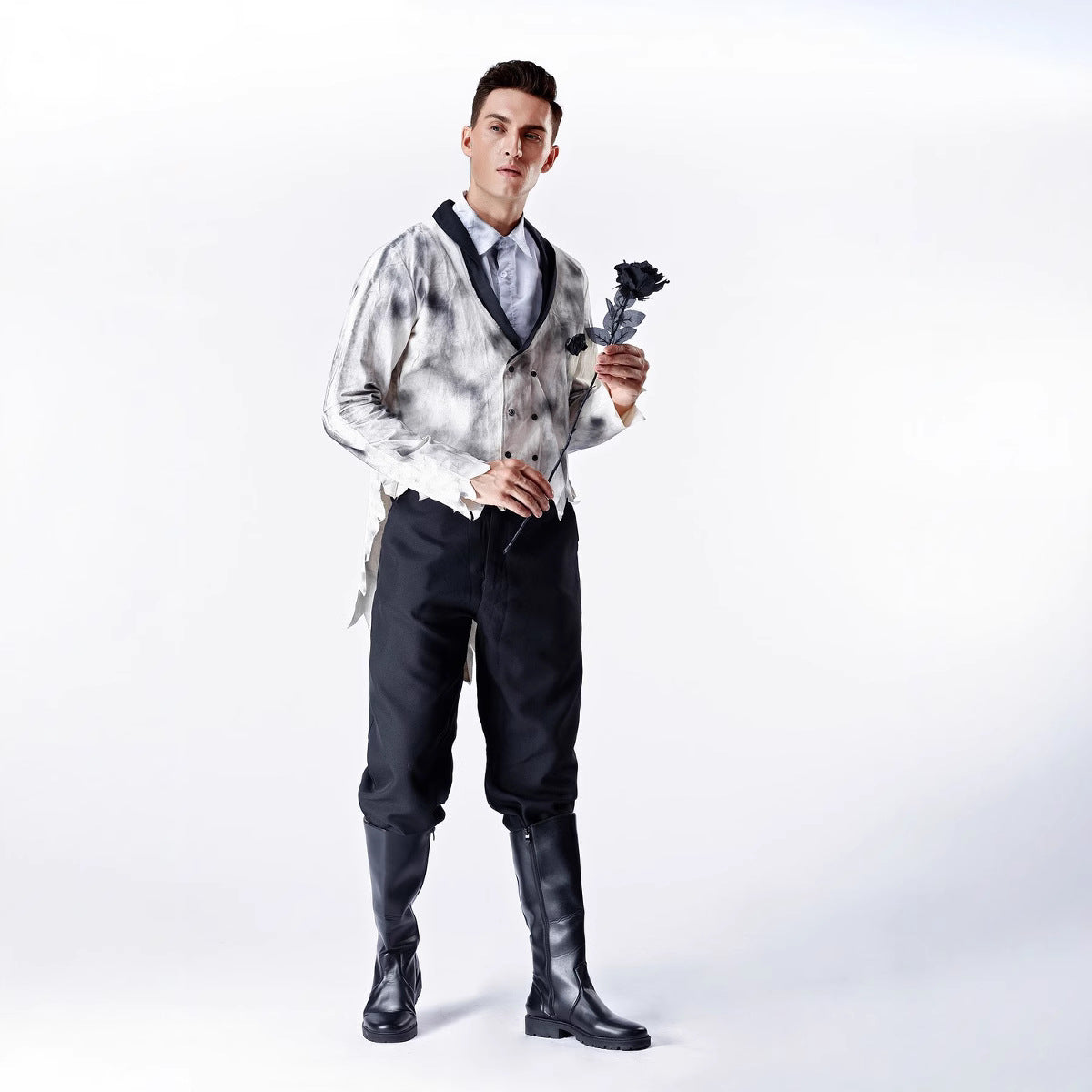 Man in formal attire holding a flower against a white background