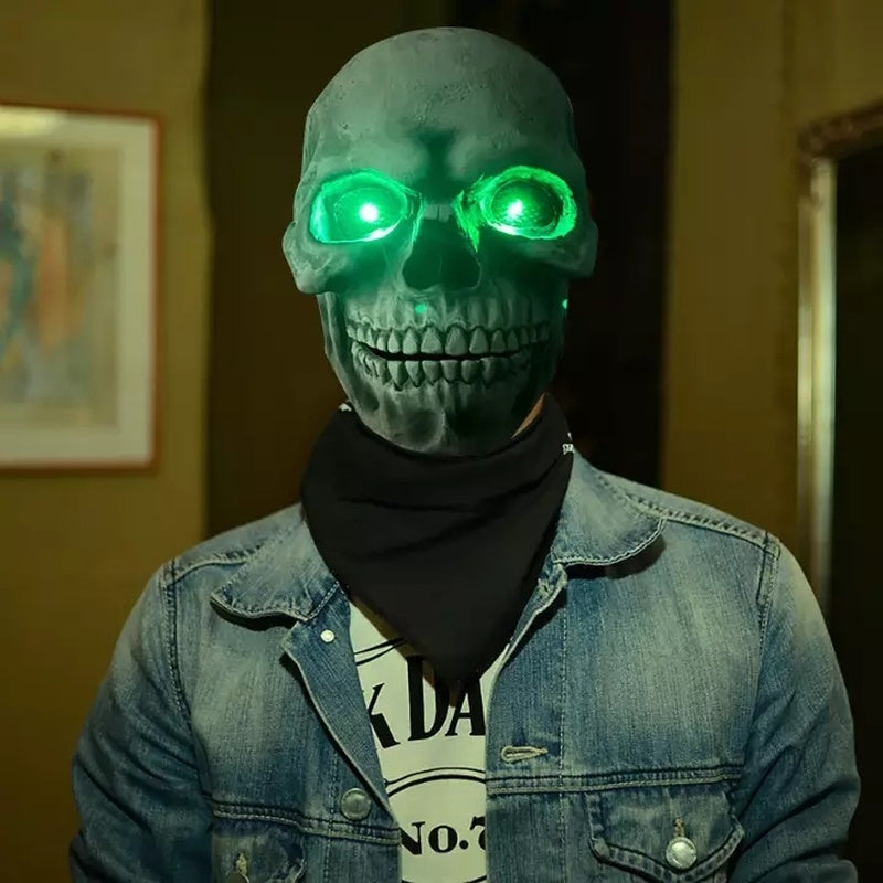 Person wearing a glowing green skull mask indoors