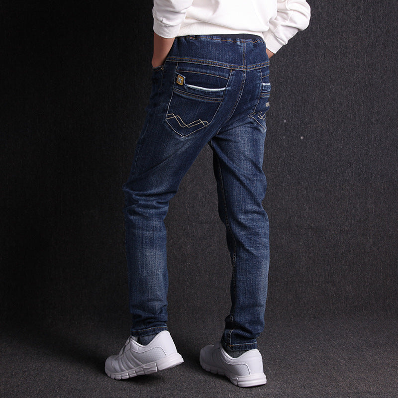Person wearing blue jeans and white sneakers on a black background