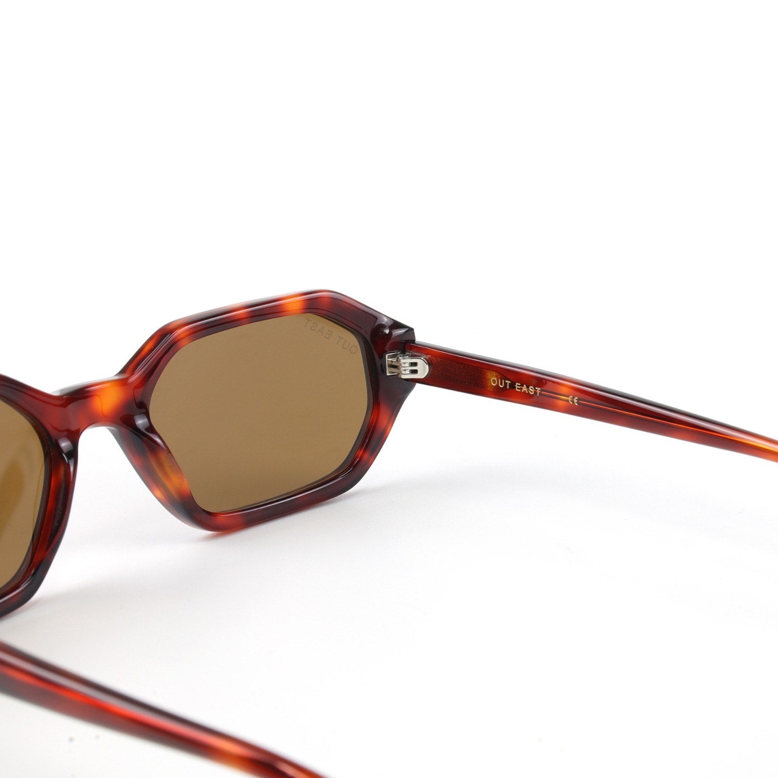 Sunglasses with tortoiseshell frame and brown lenses on a white background