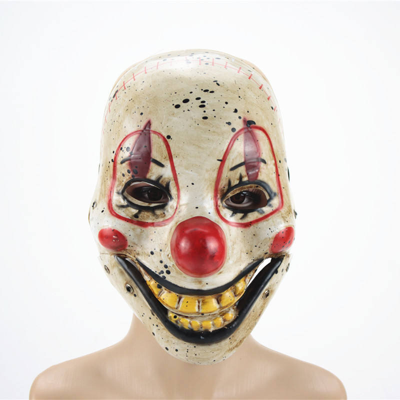 Clown mask with white face, red nose, and black eyes on a mannequin head against a white background