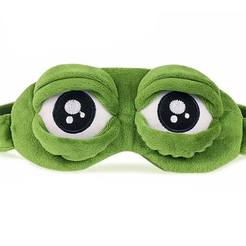 Person wearing a green frog-shaped eye mask while lying down.