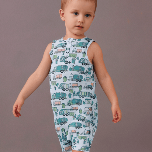 Child wearing a sleeveless romper with truck pattern on a plain background