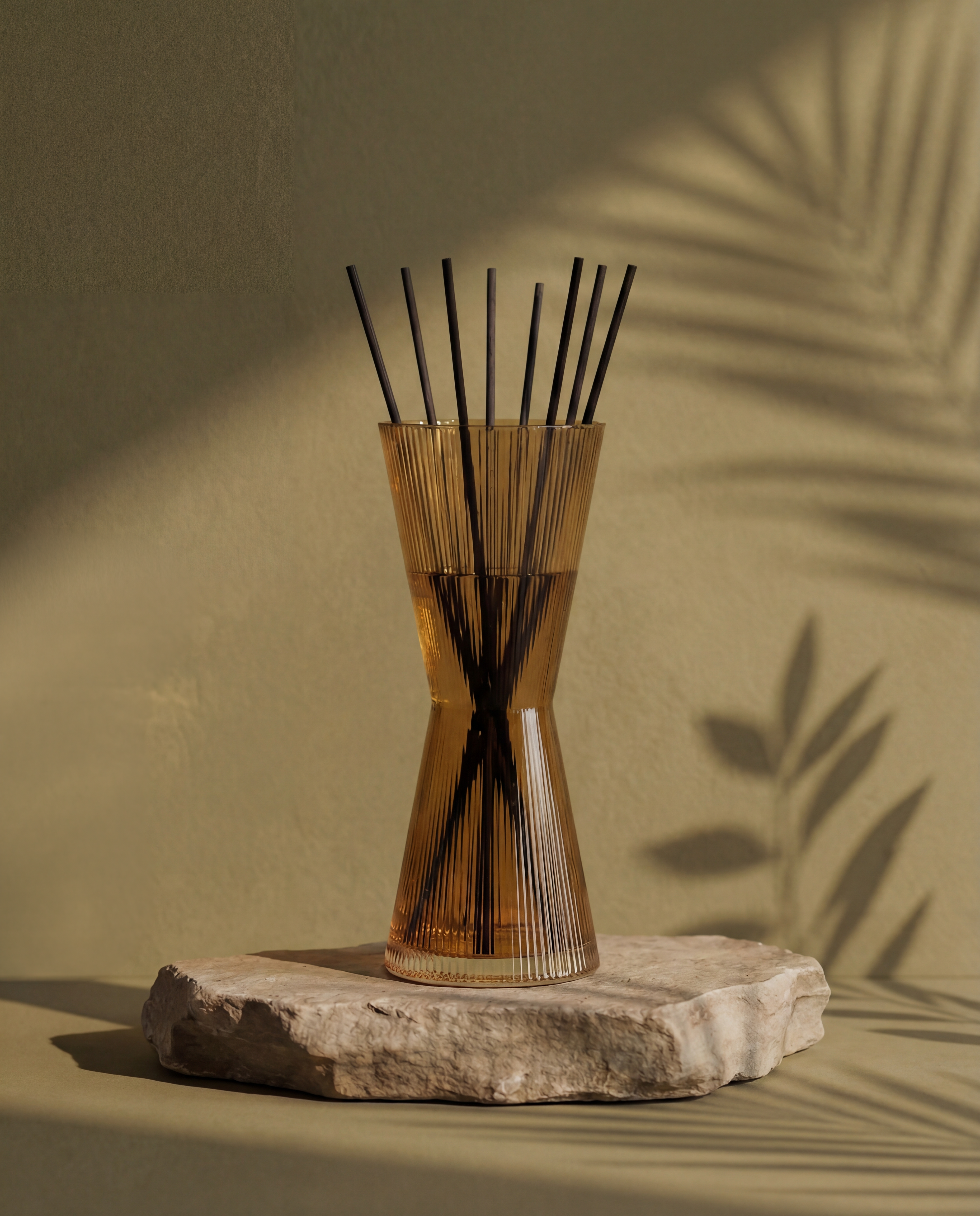 Bamboo diffuser with reeds on a stone base against a beige background