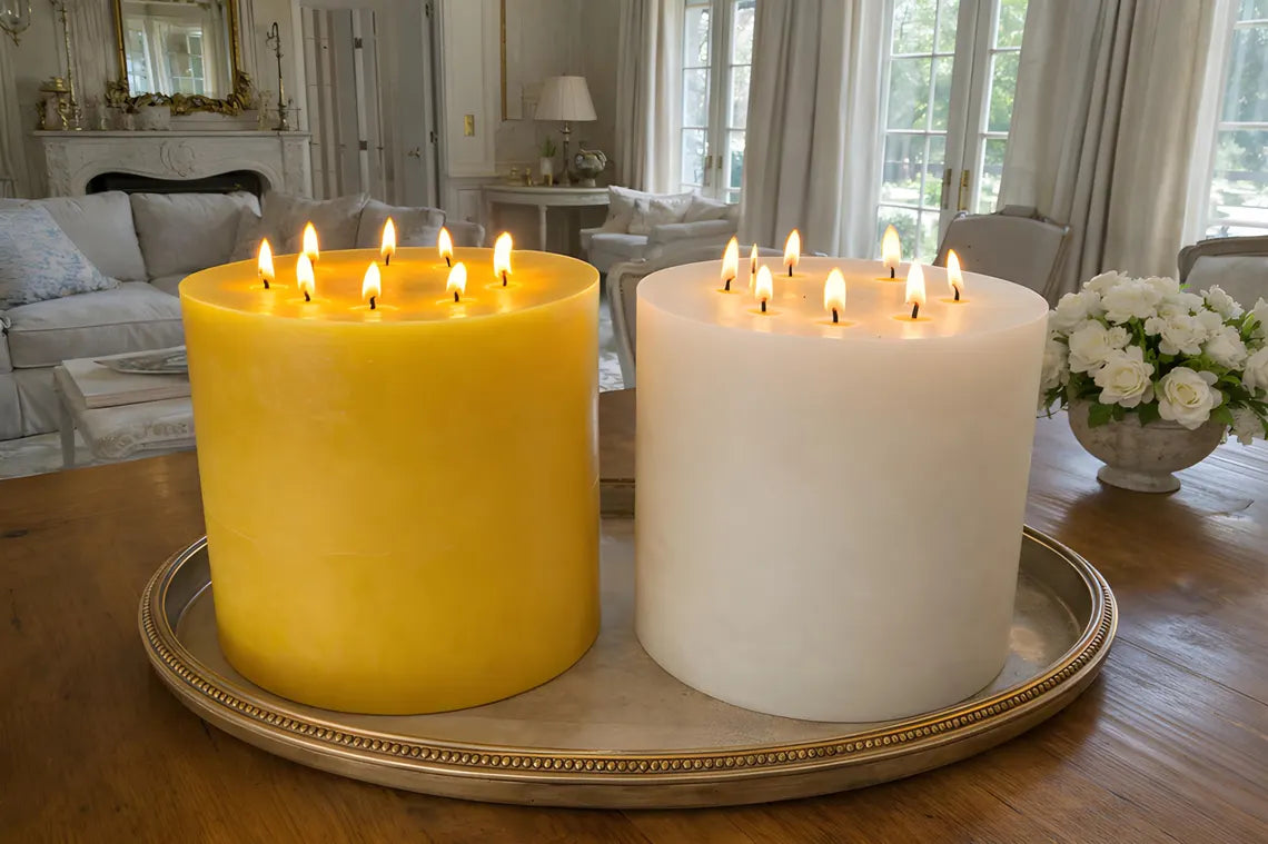 Two lit candles, one yellow and one white, on a decorative tray in a living room.