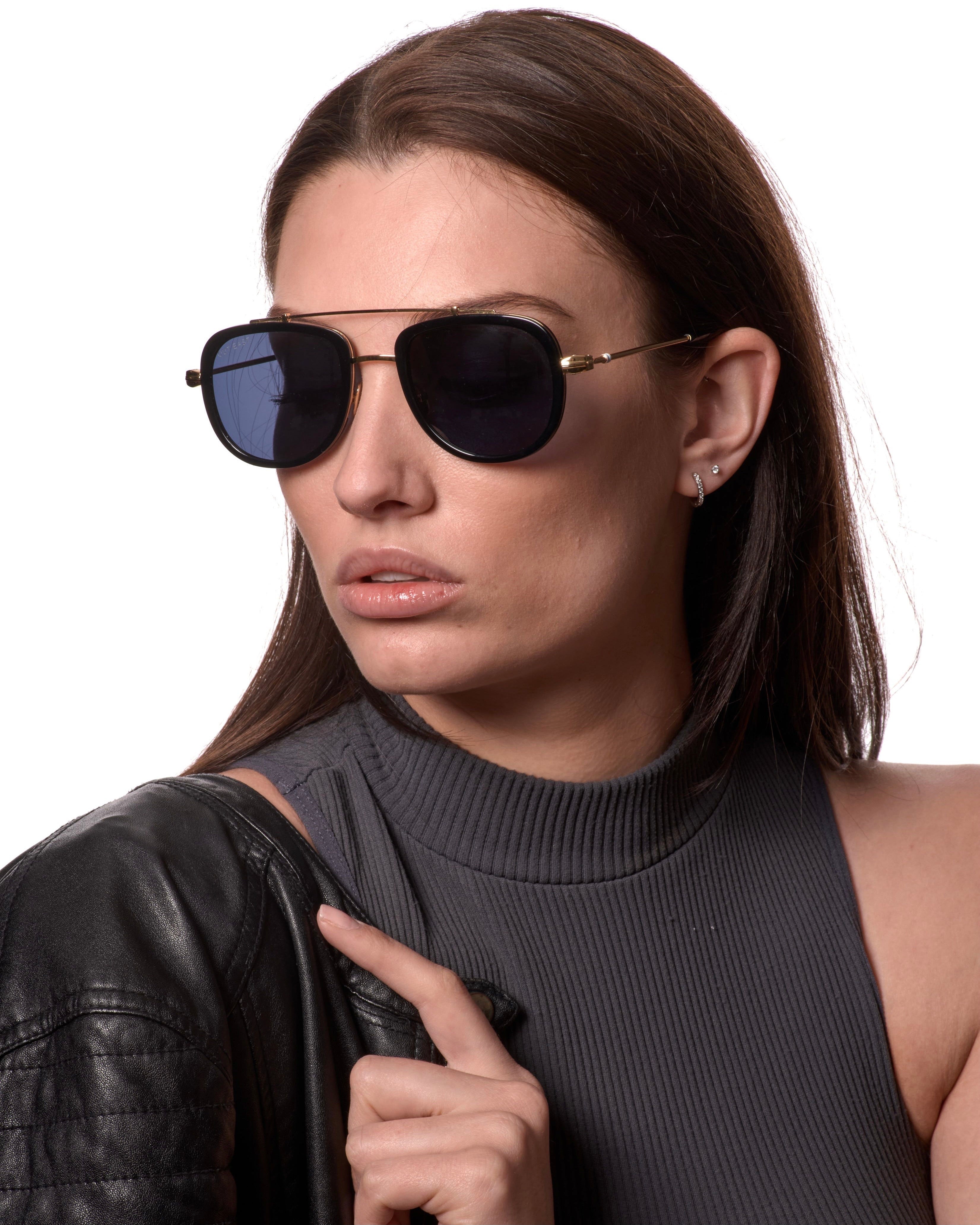Woman wearing sunglasses and a black leather jacket on a white background