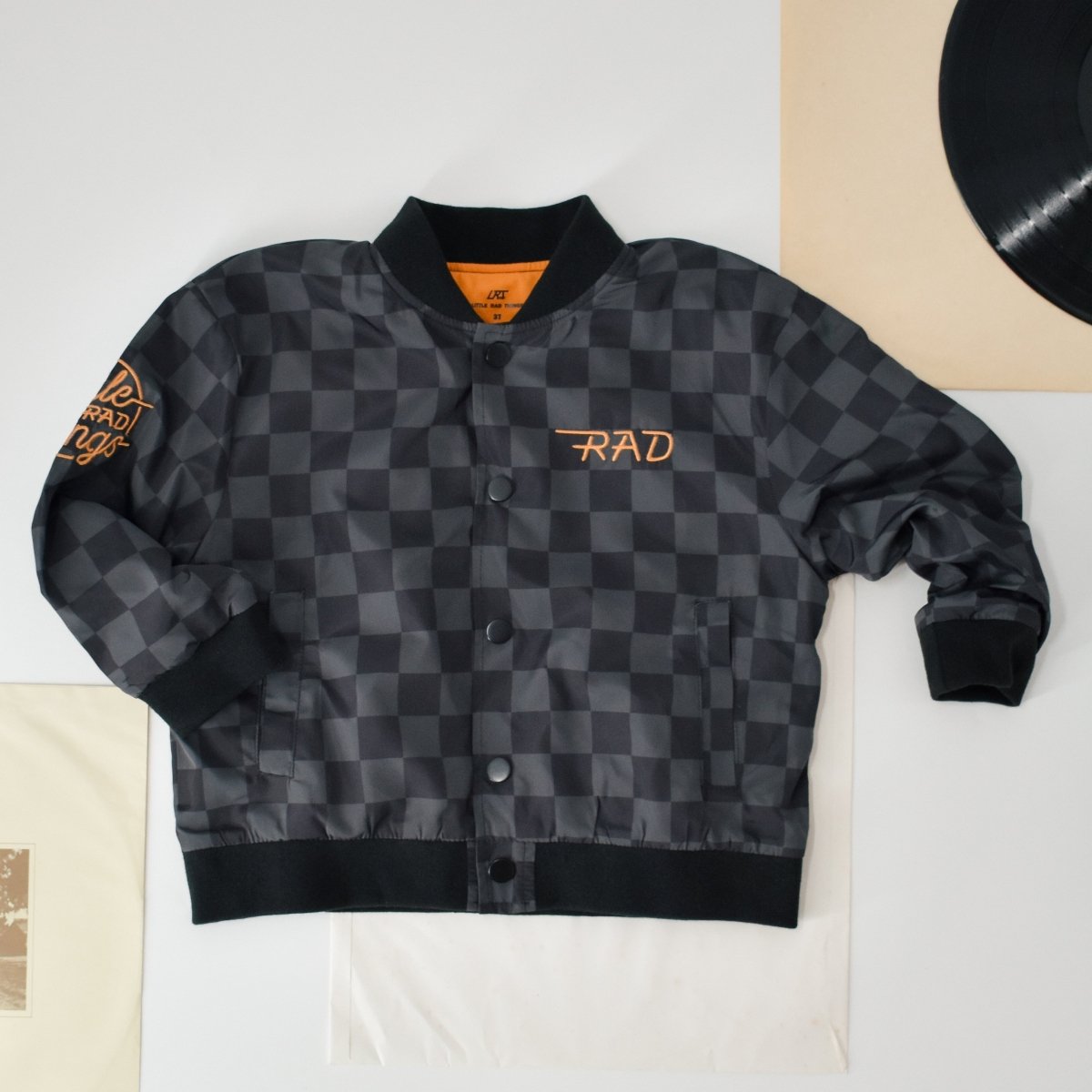 Black checkered jacket with 'RAD' logo on a light background