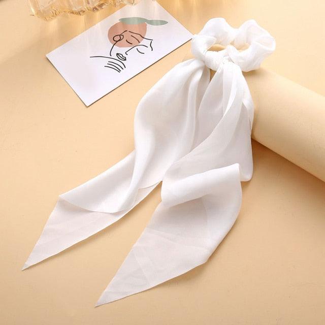 White hair scarf with a bow on a beige background