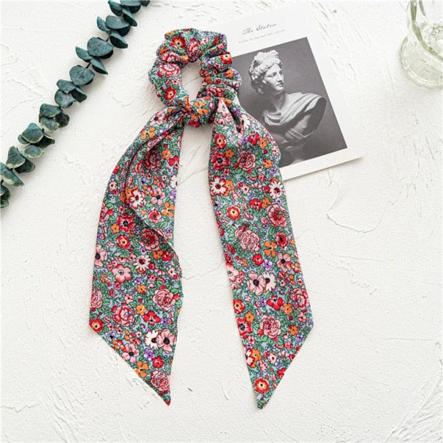 Floral patterned scarf on a textured white surface with decorative elements.